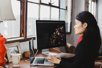 woman working at her desk looking at a computer