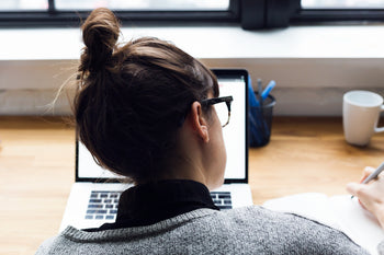 woman taking notes at a desk